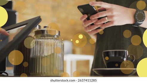 Image of falling yellow dots over people using payment terminal. Global business, finances, data processing and digital interface concept digitally generated image.