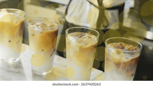 Image of falling yellow dots over ice coffee. Global business, finances, data processing and digital interface concept digitally generated image.