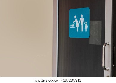 Image Of Family Restroom Sign Shown On Slide Door Of Public Toilet With Clear Light Brown Coloring Wall For Copy Space Background. 