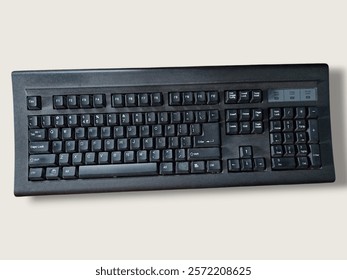 The image features a black keyboard placed on a white surface. This keyboard serves as an input device for computers and includes various components like the space bar and numeric keypad.