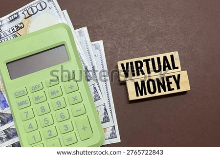The image features a light green calculator placed on top of some United States dollar bills, alongside wooden blocks with the text 