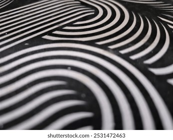 The image features a pattern of white, curved lines on a dark background. The lines are arranged in a series of overlapping and interlocking arcs, creating a dynamic, wavy design.