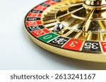 Image features a spinning roulette wheel, with a blurred metal ball, numbered betting areas in red and black, a green 0 pocket, white-marked additional betting options Background is non-descript