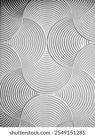 The image features a textured background with overlapping circular patterns. Each circle is detailed with concentric grooves, creating a geometric and tactile visual effect in grayscale tones.