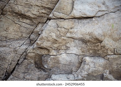 An image featuring a rocky surface with a combination of brown and white colors. The stone appears to be made of stone, and it has a rough texture, adding depth and character to the natural formation.