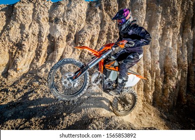 Image Of A Female Dirt Biker Jumping Up A Rocky Section Of Trail