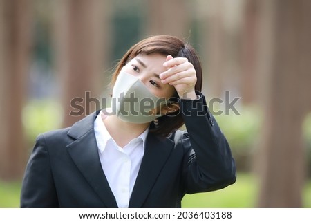 Image of a female employee who wipes sweat 