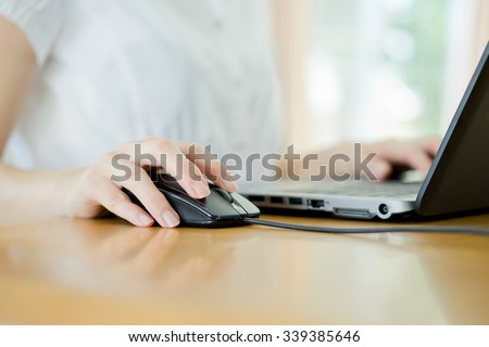 Image of female hands clicking computer mouse