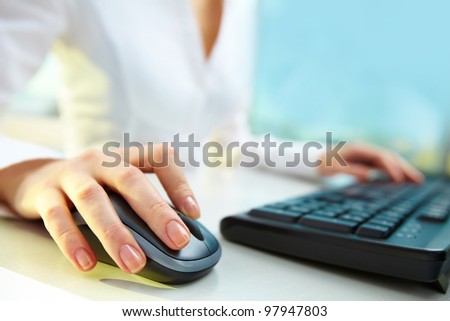 Image of female hands clicking computer mouse