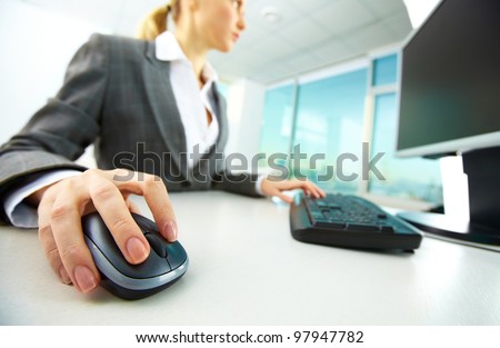 Image of female hands pushing keys of a computer mouse and keyboard