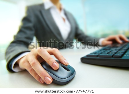 Image of female hands pushing keys of a computer mouse and keyboard