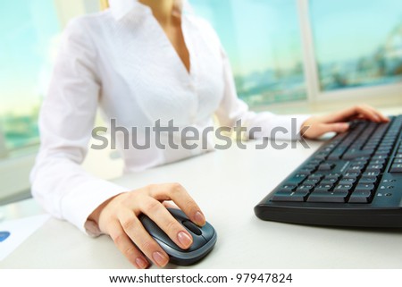 Image of female hands pushing keys of a computer mouse and keyboard