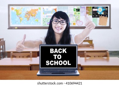 Image Of A Female High School Student Showing Thumbs Up With A Text Of Back To School On The Laptop Screen