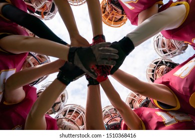 Image of female rugby players stacking their hands together - Powered by Shutterstock