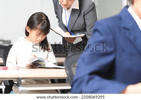 Image of a female student and a cram school teacher studying during class
