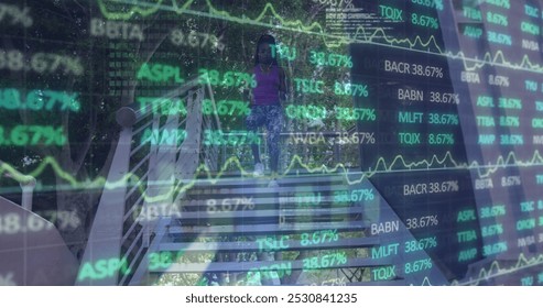 Image of financial data and graphs over african american woman running on stairs. Global business, city life, finance and economy concept digitally generated image. - Powered by Shutterstock