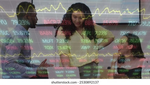 Image of financial data and graphs over diverse businesspeople in office. Business, finance, economy, cooperation and communication concept digitally generated image.
