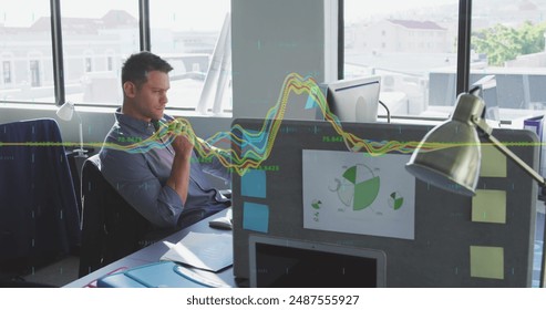 Image of financial data processing against thoughtful caucasian man sitting at office. Business data and analytics technology concept