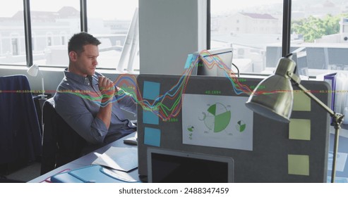 Image of financial data processing against thoughtful caucasian man sitting at office. Business data and analytics technology concept