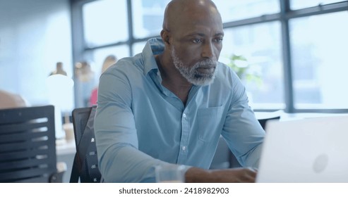 Image of financial data processing over african american businessman in office. Global finance, business, connections, computing and data processing concept digitally generated image.