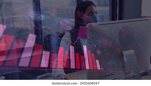 Image of financial data processing over businesswoman with face mask using computer in office. global business and digital interface during covid 19 pandemic concept digitally generated image.