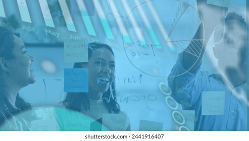 Image of financial data processing over diverse business people in office. Global business and digital interface concept digitally generated image.