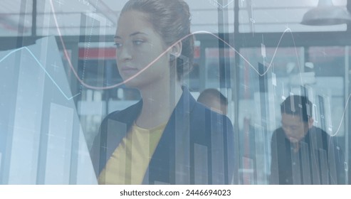 Image of financial data processing over diverse business people working in modern office. global business, finances, connections and digital interface concept digitally generated image.