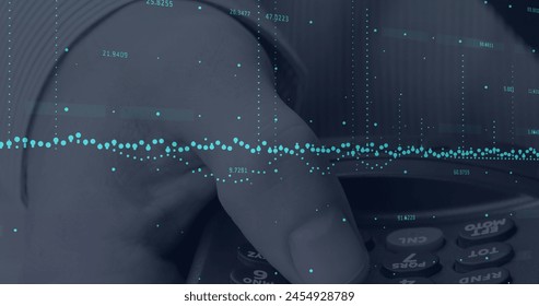 Image of financial data processing over hand holding calculator. global business, finances and digital interface concept digitally generated image.
