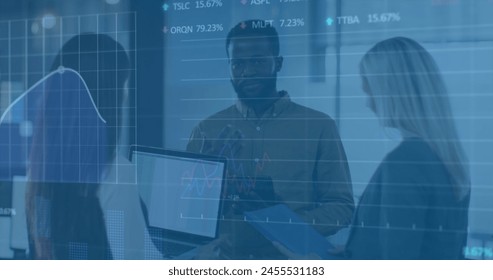 Image of financial data processing over diverse business people in office. Global business and digital interface concept digitally generated image.