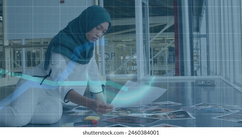 Image of financial data processing over biracial businesswoman working at office. Global business, finances and digital interface concept, digitally generated image.