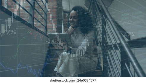 Image of financial data processing over biracial businesswoman in office. Global business, finance, computing and data processing concept digitally generated image.