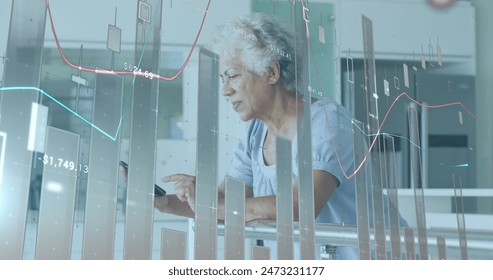 Image of financial data processing over senior african american woman using smartphone. Global business, finances and digital interface concept digitally generated image.