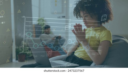 Image of financial data processing over biracial businesswoman working in office. Global business, finance, computing and data processing concept digitally generated image.