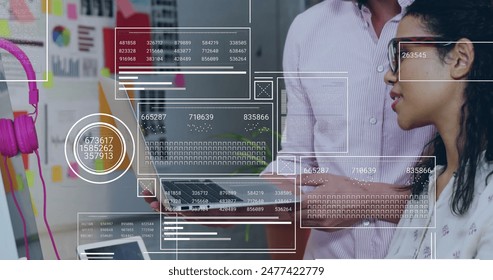 Image of financial data processing over diverse business people using laptop. Global business, finance, digital interface, computing and data processing concept digitally generated image.