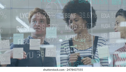 Image of financial data processing over diverse colleagues discussing over glass board at office. Global economy and business technology concept