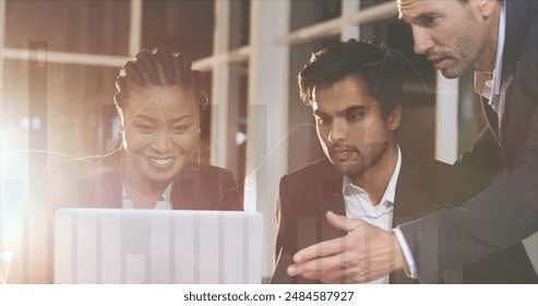 Image of financial data processing over diverse male and female colleagues using laptop. Global finances, business, communication and digital interface concept digitally generated image.