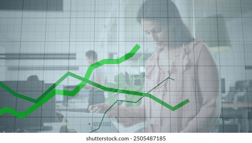 Image of financial data processing over caucasian businesswoman using tablet in office. Global business, computing, communication and digital interface concept digitally generated image.