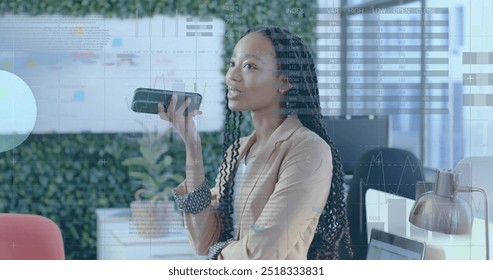 Image of financial data processing over african american businesswoman in office. Global finance, business, connections, computing and data processing concept digitally generated image.