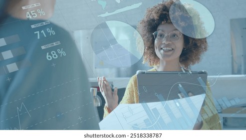 Image of financial data processing over african american businesswoman in office. Global finance, business, connections, computing and data processing concept digitally generated image.