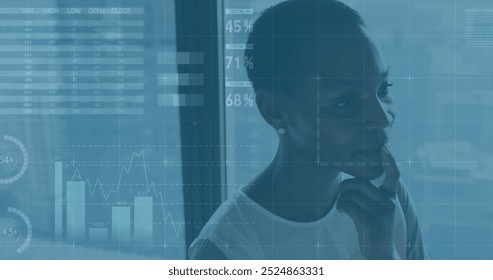 Image of financial data processing over african american businesswoman in office. Global finance, business, connections, computing and data processing concept digitally generated image.