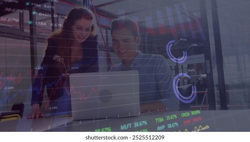 Image of financial data processing over diverse business people using laptop. Global finance, business, connections, computing and data processing concept digitally generated image.