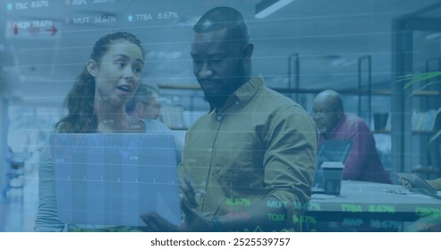 Image of financial data processing over diverse business people using laptop. Global finance, business, connections, computing and data processing concept digitally generated image.
