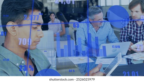 Image of financial data processing over diverse business people working in office. Global business, finances, computing and data processing concept digitally generated image.