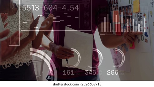 Image of financial data processing over diverse business people working at office. Global business, finances and digital interface concept digitally generated image.