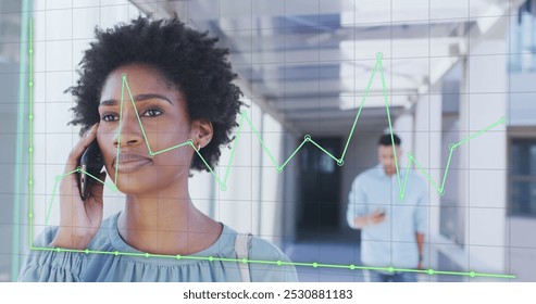 Image of financial data processing over african american businesswoman talking on smartphone. Global business, finances and digital interface concept digitally generated image. - Powered by Shutterstock