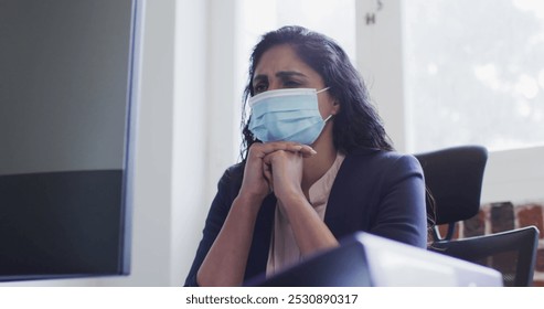 Image of financial data processing over businesswoman wearing face mask. global business, finances, connections and digital interface during covid 19 pandemic concept digitally generated image. - Powered by Shutterstock