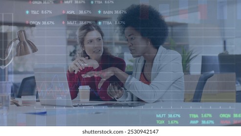 Image of financial data processing over diverse businesswomen in office. Global business, finance, computing and data processing concept digitally generated image.