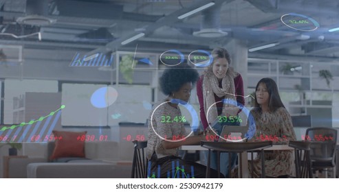 Image of financial data processing over diverse businesswomen in office. Global business, finance, computing and data processing concept digitally generated image.
