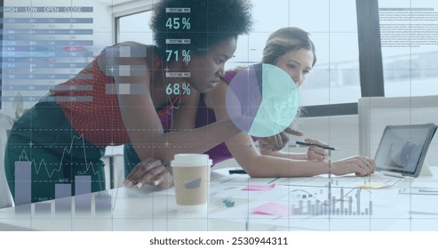 Image of financial data processing over diverse businesswomen in office. Global business, finance, computing and data processing concept digitally generated image.