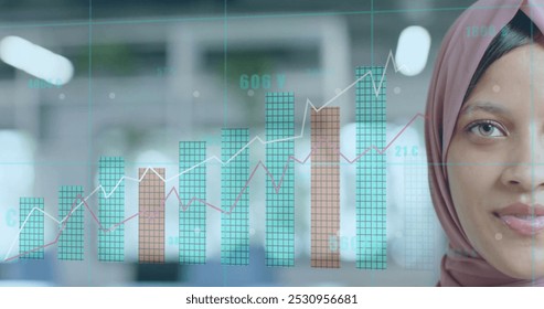 Image of financial data processing over biracial businesswoman in hijab in office. Global business, finance, computing and data processing concept digitally generated image. - Powered by Shutterstock